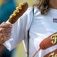 Woman holding corn dog wearing shirt that reads "Fair Food"